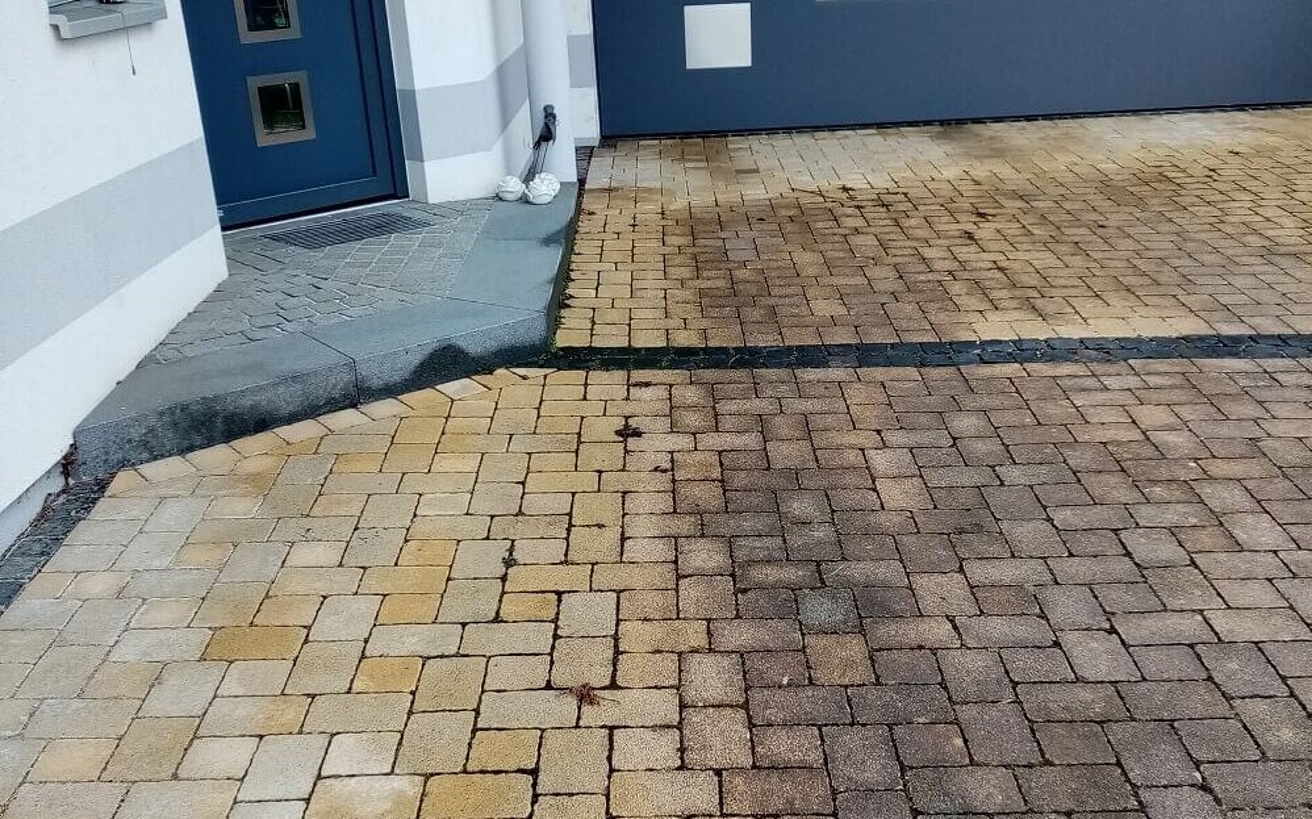Bewitterte Hofeinfahrt nach dem Winter mit dunklen Ablagerungen