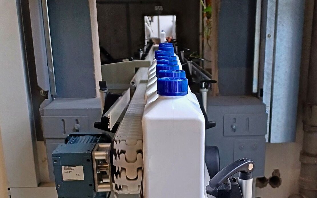 Förderband - Lithofin Flasche im Vordergrund